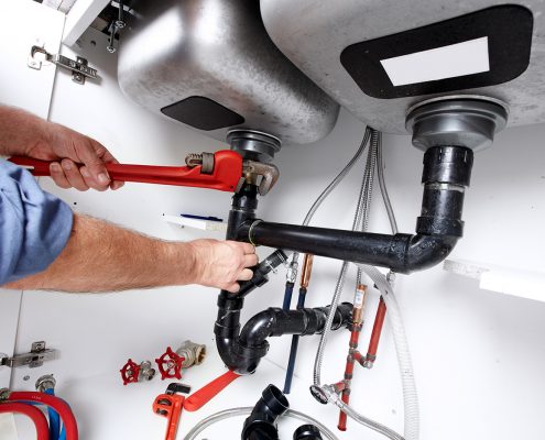 Commercial plumber fixing a broken pipe photo